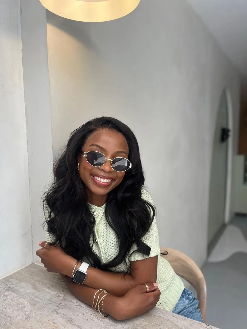 Kat smiling in sunglasses, leaning on a stone table